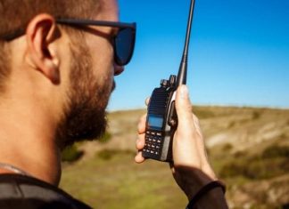 What Is The Best Emergency Communication? man talking walkie talkie radio enjoying canyon